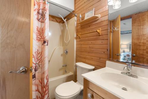 a bathroom with a toilet and a sink and a shower at Y-Worry in Kill Devil Hills