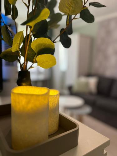 a yellow vase sitting on a table with a plant at Apartament Piaskowa Mountain & Coffee in Wałbrzych