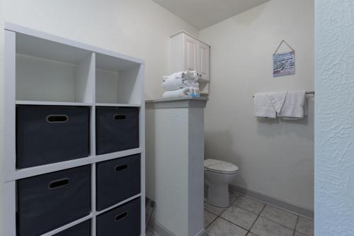 a small bathroom with a toilet and a cabinet at Turtle Time Retreat in Foley