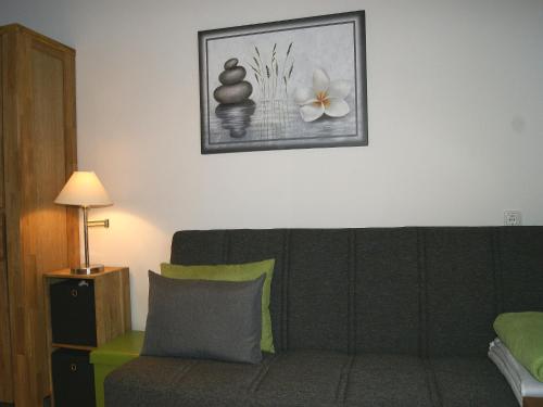 a living room with a green couch and a picture on the wall at Apartment am Wolfgangsee in Strobl