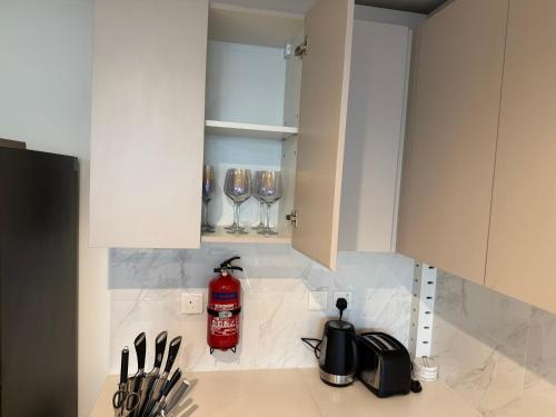 a kitchen with white cabinets and wine glasses at Dubai Frame Views Steps from Metro & Sheikh Zayed Road in Dubai