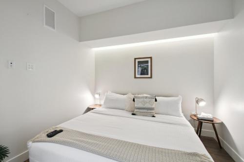 - une chambre blanche avec un grand lit aux murs blancs dans l'établissement Urban Elegance | Espadin LoHi, à Denver