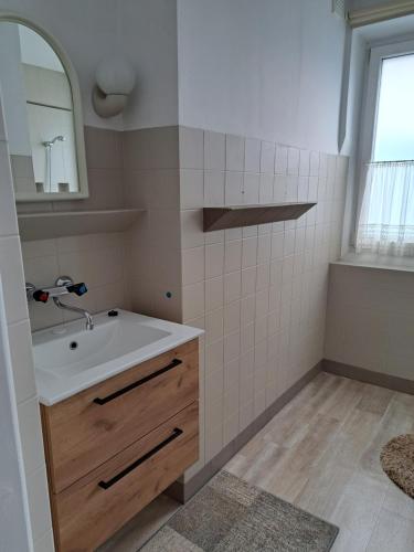 a bathroom with a sink and a mirror at Apartament wakacyjny Chałupy in Chałupy