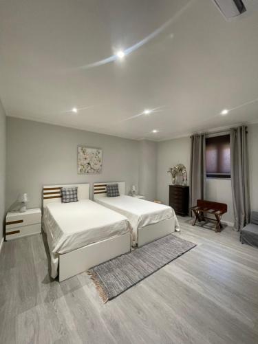 a bedroom with a large white bed in a room at Casa da Burra in Alijó