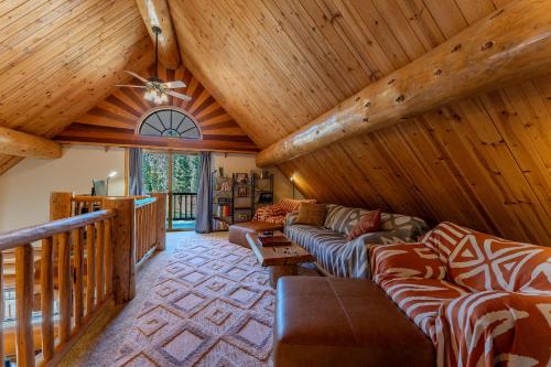a living room with couches and a wooden ceiling at Peppermint Falls Ranch in Ponderosa
