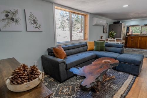 a living room with a blue couch and a table at Peppermint Falls Ranch in Ponderosa