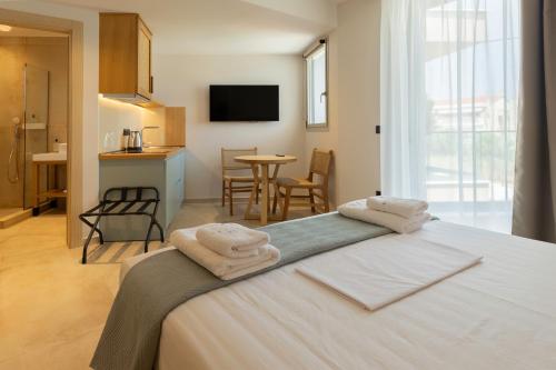 a bedroom with a large bed with towels on it at Thines Comfort Living in Néa Péramos