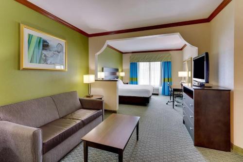 a living room with a couch and a bedroom at Comfort Inn & Suites in Waco