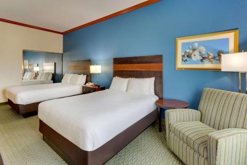 a hotel room with two beds and a couch at Comfort Inn & Suites in Waco