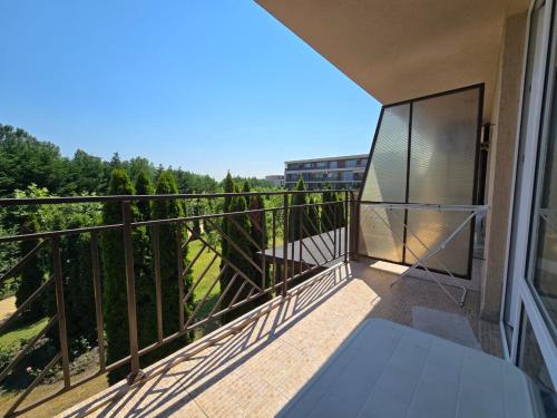 a balcony with a view of trees and a building at Orchid Fort Garden in Sunny Beach