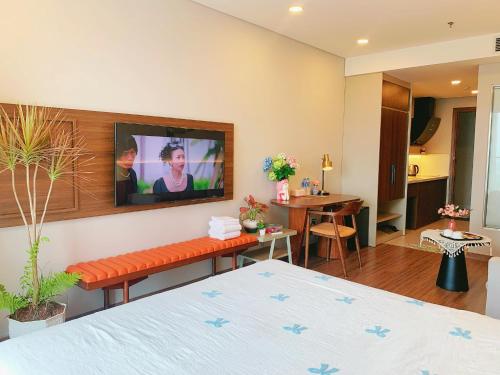 a bedroom with a bed and a tv on a wall at Homestay Apec Mandala Hotel & Suites Hai Duong in Hải Dương