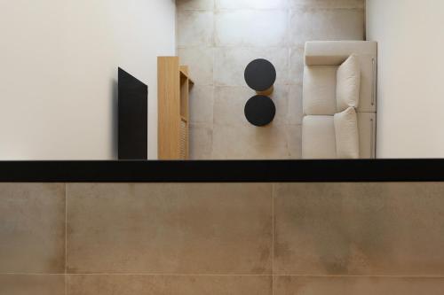 a shelf with a white chair on a wall at Thines Comfort Living in Néa Péramos