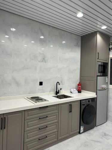 a kitchen with a sink and a dishwasher at dana hotel apartments in Taif