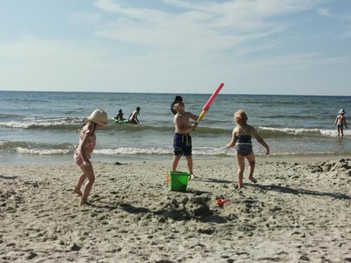 a group of people playing baseball on the beach at APARTAMENT 9B BLUE MARINE Poddąbie Basen Odkryty Brodziki Plac Zabaw in Poddąbie