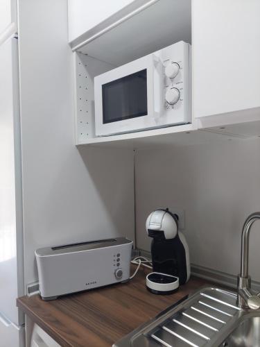 a kitchen counter with a microwave and a sink at El Rincón de San Fermín in Zizur Mayor