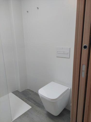 a bathroom with a white toilet in a room at El Rincón de San Fermín in Zizur Mayor