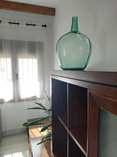 a green glass vase sitting on top of a cabinet at El Rincón de San Fermín in Zizur Mayor