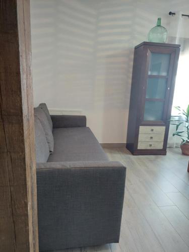 a couch sitting in a living room with a cabinet at El Rincón de San Fermín in Zizur Mayor