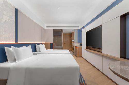 a hotel room with two beds and a flat screen tv at Holiday Inn Express Datong Pingcheng by IHG in Datong