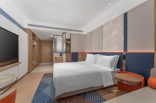 a hotel room with a bed and a tv at Holiday Inn Express Datong Pingcheng by IHG in Datong