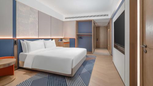 a bedroom with a large white bed and a corridor at Holiday Inn Express Datong Pingcheng by IHG in Datong