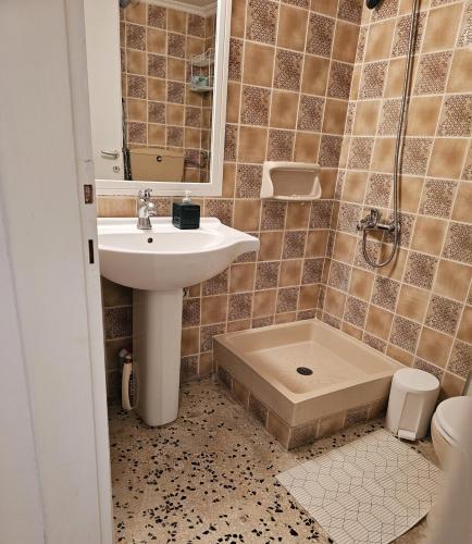 a bathroom with a sink and a shower at QUTE apartment in Hanioti