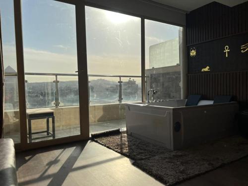 a large bathroom with a tub and a large window at New Comfort Inn Giza in Cairo