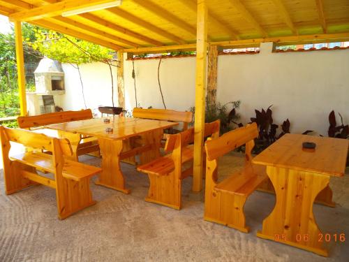 ソゾポルにあるSveti Georgi Guest Houseの木製テーブルと椅子、木製テーブルとベンチ