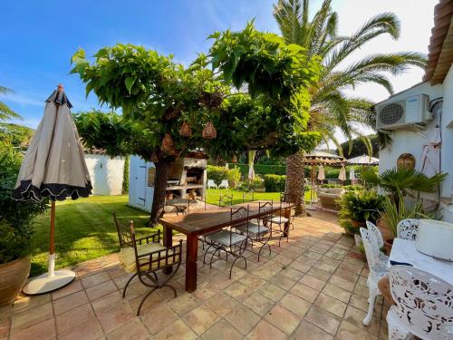 a patio with a table and chairs and an umbrella at Villa provençale Golfe St Tropez climatisée piscine chauffée, Spa, billard, Wifi haut débit pro in Gassin