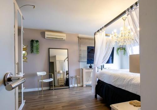 レスターにあるThe Divine Penthouse Luxuryのベッドルーム1室(シャンデリアと鏡付きのベッド1台付)
