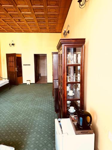 an empty room with a cabinet and a room with green carpet at ART hotel MAXIM in Frýdek-Místek