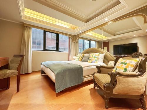 a bedroom with a bed and a chair and a television at Tai Hope Hotel in Taipei
