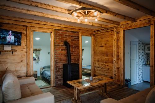 a living room with wooden walls and a fireplace at Kuća za odmor Brvnara Milanović in Gornji Milanovac