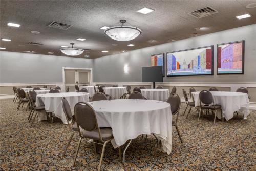 una sala conferenze con tavoli, sedie e uno schermo di Best Western Plus The Normandy Inn & Suites a Minneapolis