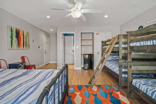a bedroom with two bunk beds and a ceiling fan at Coconut Hut - Pet Friendly! Boardwalk to the Beach! - Pet Friendly! Boardwalk to the Beach! in Mustang Beach