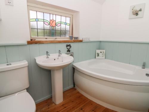 Un baño con bañera, lavabo e inodoro. en St John's House, en Newport