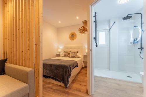 a bedroom with a bed and a shower and a tub at Apartamentos Turísticos Jardín del Albarregas in Merida