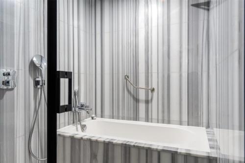 a bath tub in a bathroom with a shower at Radisson Blu Resort & Spa Cesme in Cesme