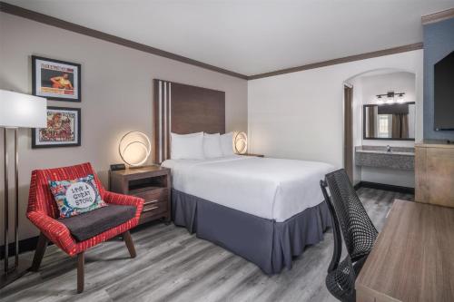 a hotel room with a bed and a chair at Aiden Austin City Hotel in Austin