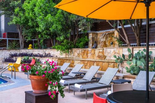 a row of chairs and an umbrella on a patio at Aiden Austin City Hotel in Austin