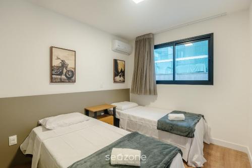 a hospital room with two beds and a window at Prédio c/ Aptos Novos a 300m da Praia - EEP in Guarapari