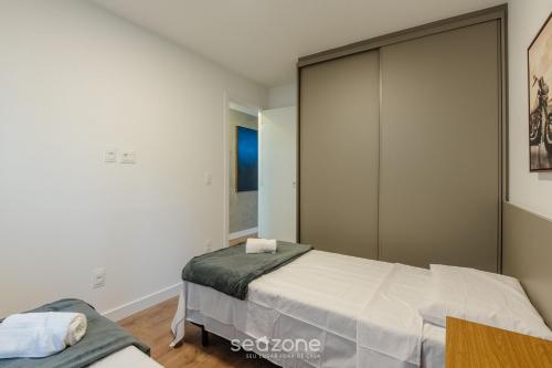 a bedroom with a bed and a large closet at Prédio c/ Aptos Novos a 300m da Praia - EEP in Guarapari