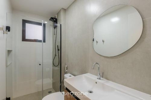 a bathroom with a sink and a mirror and a shower at Prédio c/ Aptos Novos a 300m da Praia - EEP in Guarapari