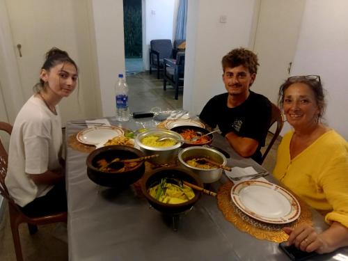 a group of people sitting at a table with food at Rose Palace in Nuwara Eliya