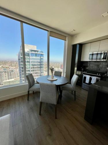 a living room with a table and chairs and a large window at The Daisy-Highrise 2BR Marina View,Pool,Jacuzzi,Gym&Parking in San Diego