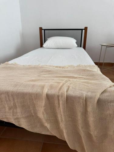 a bed with a white blanket on top of it at Tinos beauty village in Kalloní