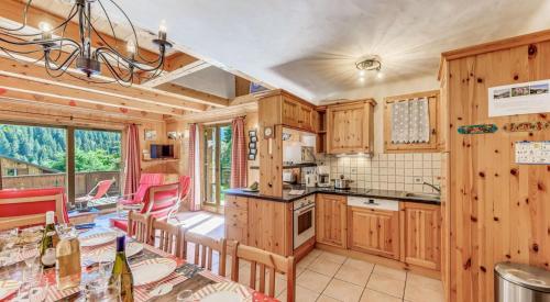 une cuisine avec des armoires en bois et une table avec des chaises dans l'établissement Résidence Les Soldanelles - Chalets pour 10 Personnes MAE-2760, à Champagny-en-Vanoise