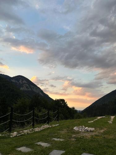 a fence in a field with mountains in the background at A Way To Nature in Măgura
