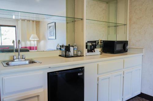 a kitchen with a counter with a dishwasher and a sink at La Hacienda San Jose Silicon Valley in San Jose