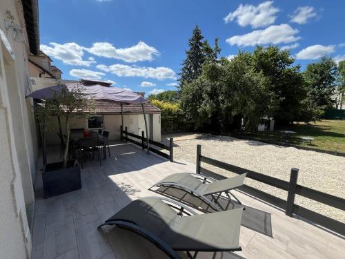 a patio with chairs and a table and a fence at Maison avec terrasse et jardin in Avallon